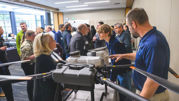 Adults and students discussing drones
