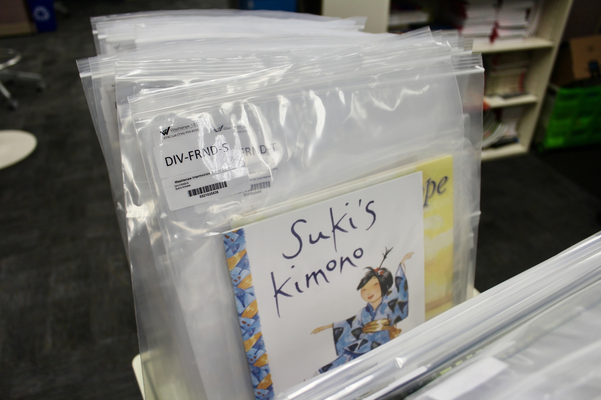 The book suki's kimono sits in a catalog bag with other books on cart